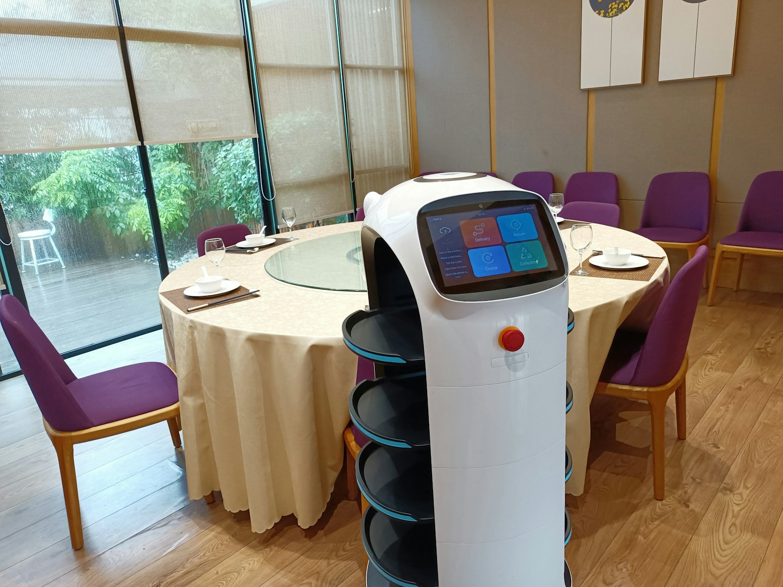 A delivery robot beside a set table in a hotel dining room